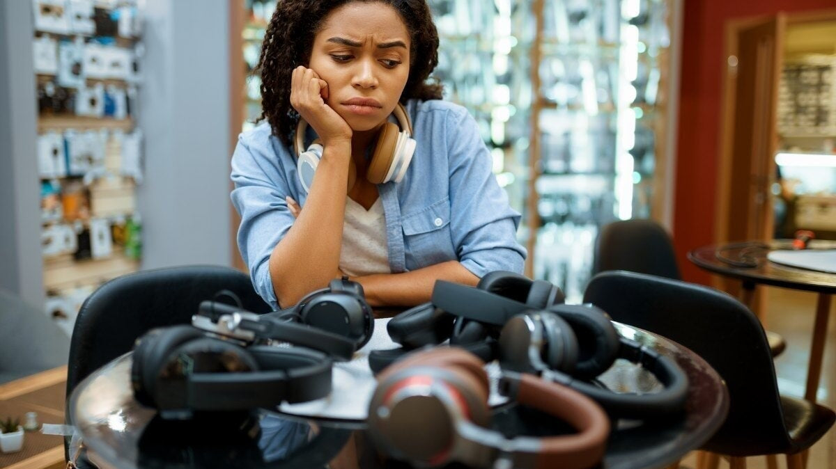 une femme choisissant des écouteurs dans un magasin de systèmes de haut-parleurs