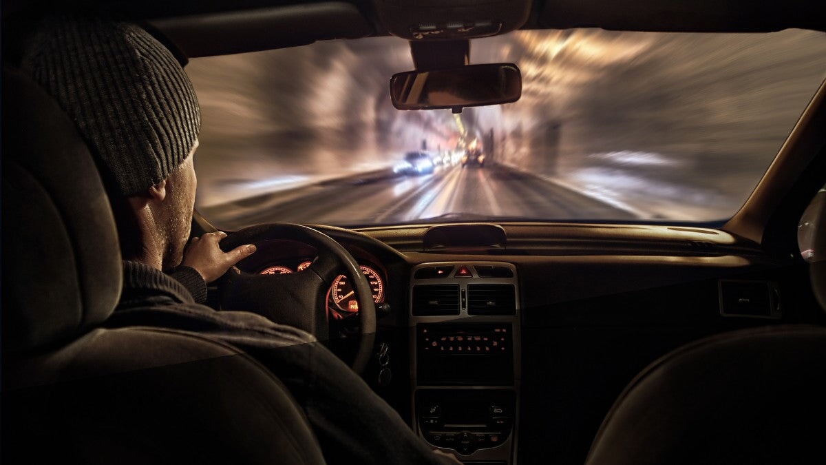 un homme conduisant une voiture dans la nuit