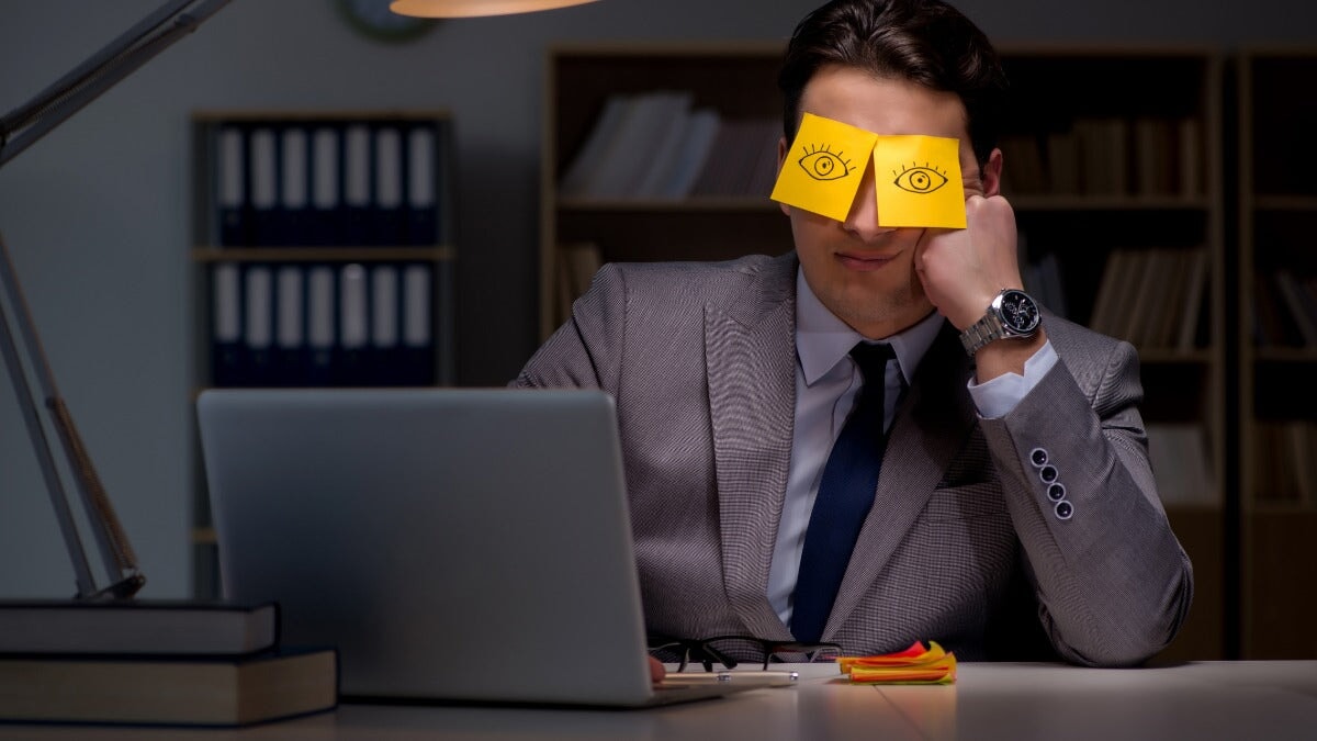 un homme d'affaires fatigué faisant des heures supplémentaires au bureau