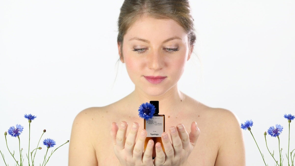 une femme regardant une bouteille d'eau de bleuet dans sa main